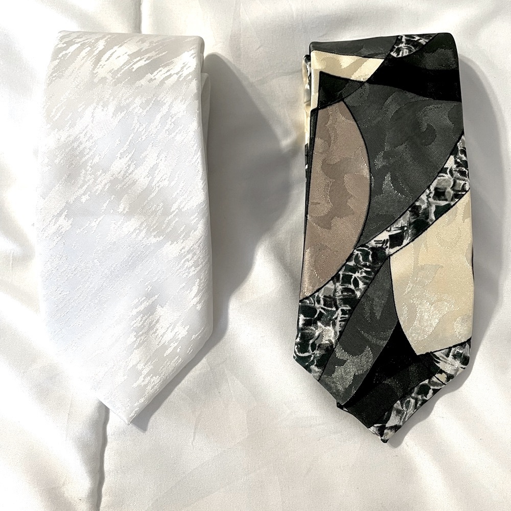 Two youth-size neckties by Michael James, one solid white, one green/tan pattern